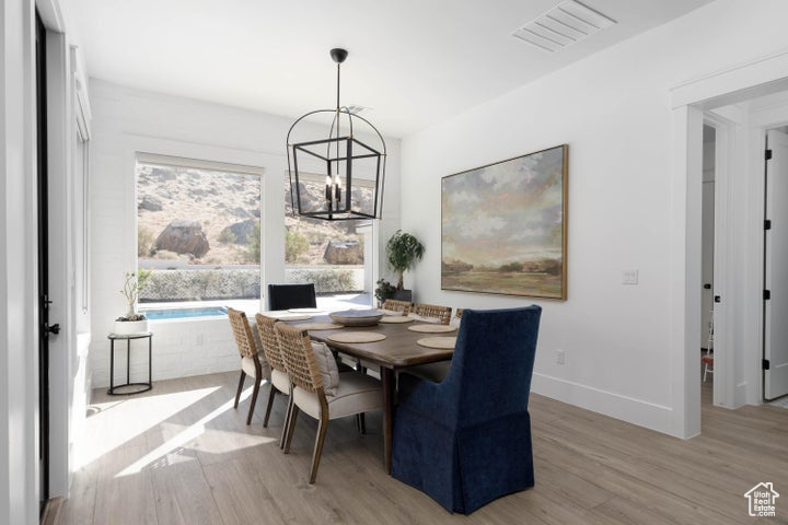 Dining room with a notable chandelier and light wood-type flooring