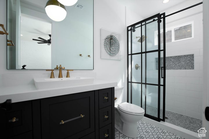 Bathroom with ceiling fan, vanity, walk in shower, and toilet