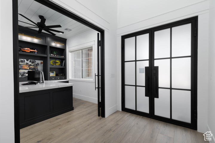 Unfurnished office featuring light wood-type flooring and ceiling fan