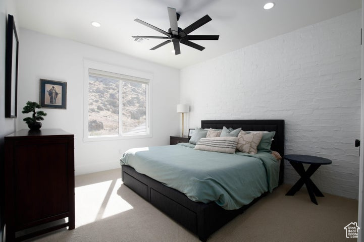 Bedroom with ceiling fan and light carpet