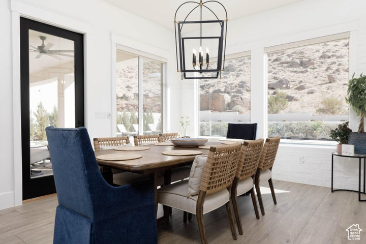 Dining area featuring ceiling fan with notable chandelier and light wood-type flooring