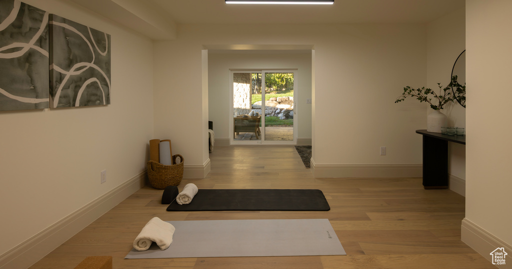 Exercise room with light hardwood / wood-style floors