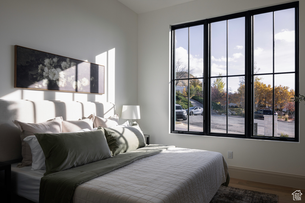 Bedroom with multiple windows and wood-type flooring