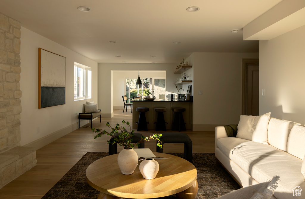 Living room with wood-type flooring and a stone fireplace