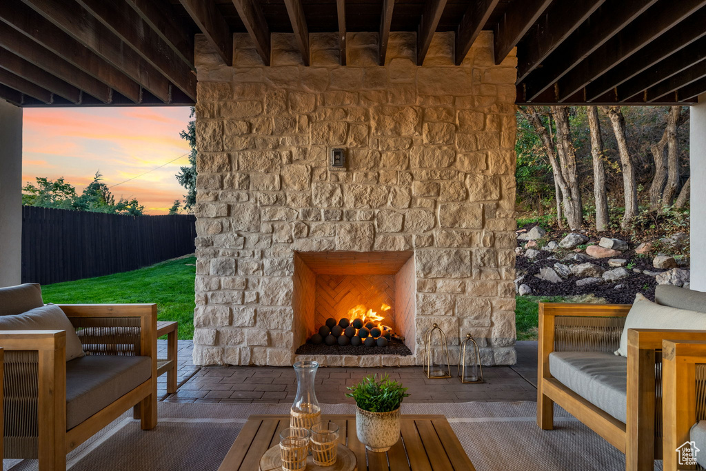 Patio terrace at dusk with an outdoor stone fireplace