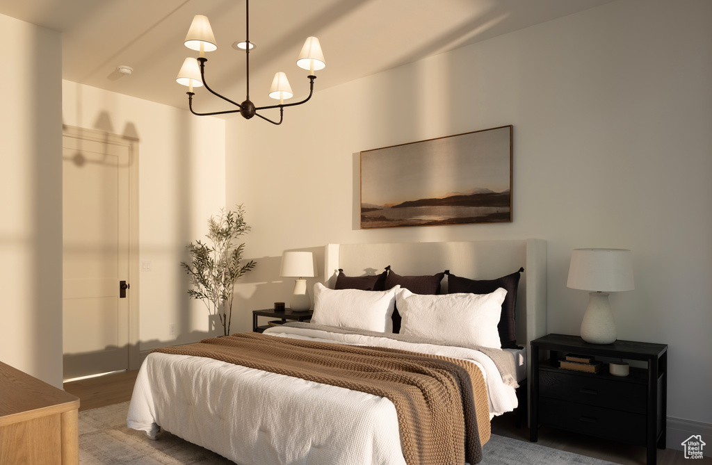 Bedroom featuring hardwood / wood-style flooring and an inviting chandelier