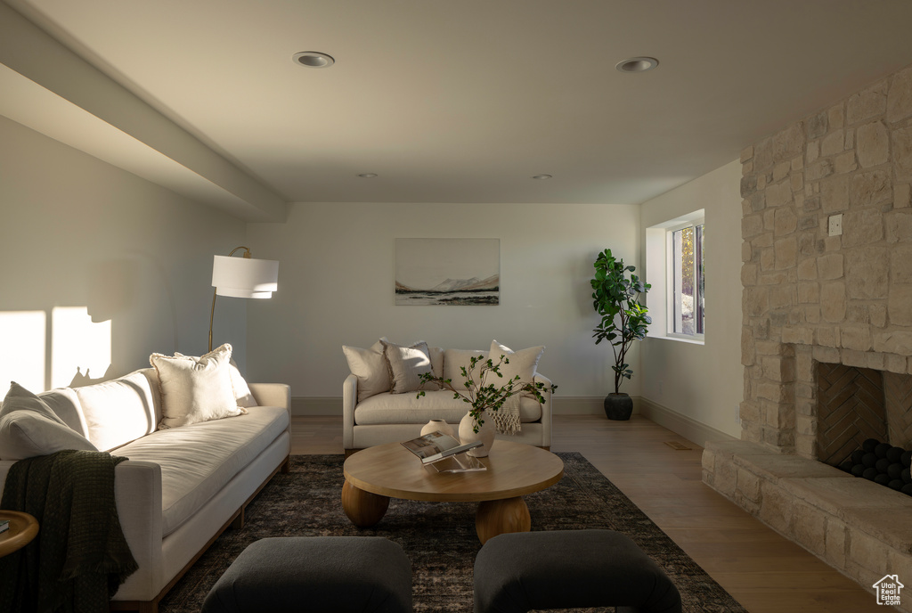 Living room with wood-type flooring and a stone fireplace