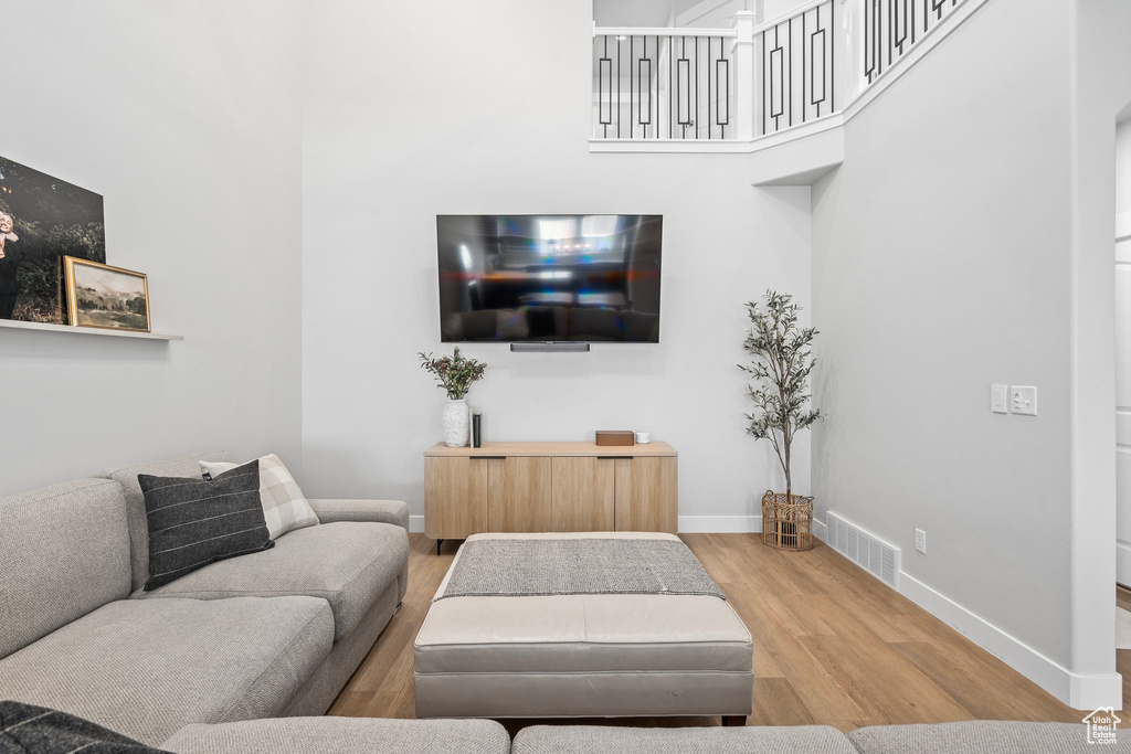 Living room featuring hardwood / wood-style flooring and a towering ceiling