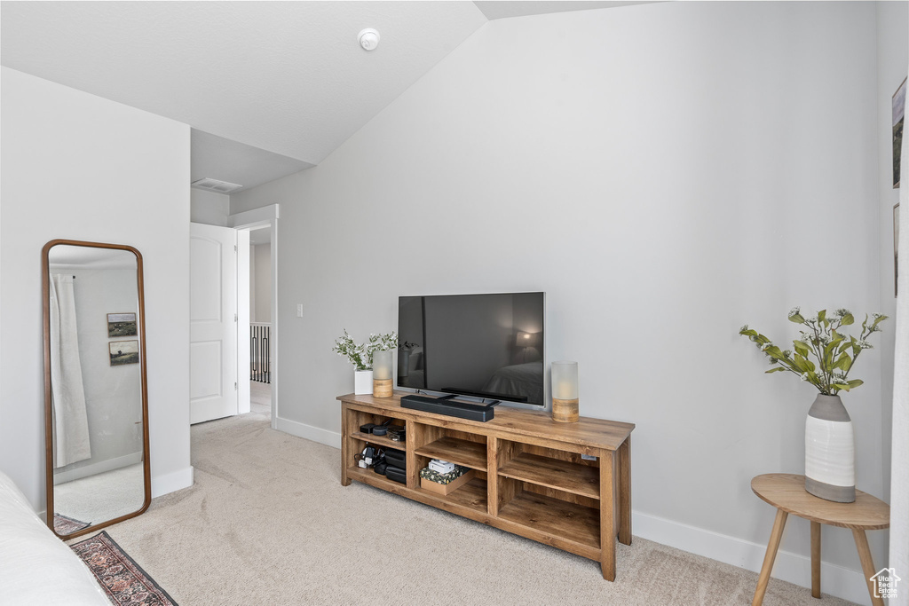 Living room with lofted ceiling and light carpet