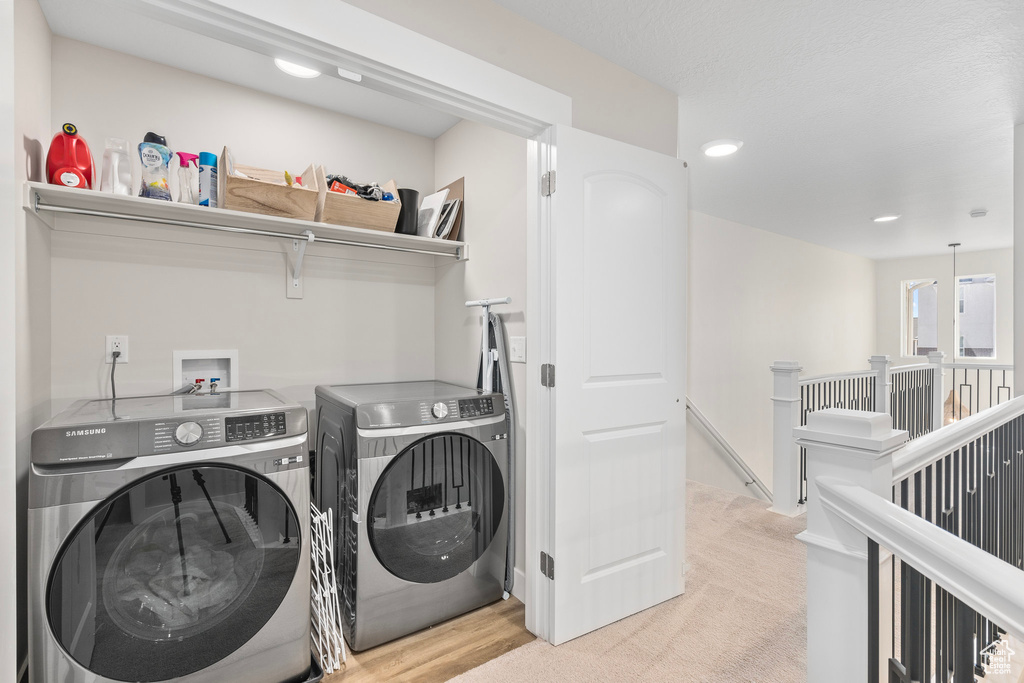 Laundry area featuring washer and dryer and light carpet