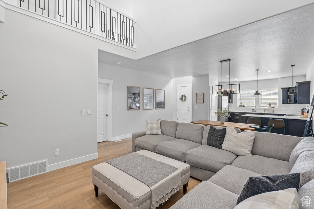 Living room featuring an inviting chandelier and light hardwood / wood-style flooring