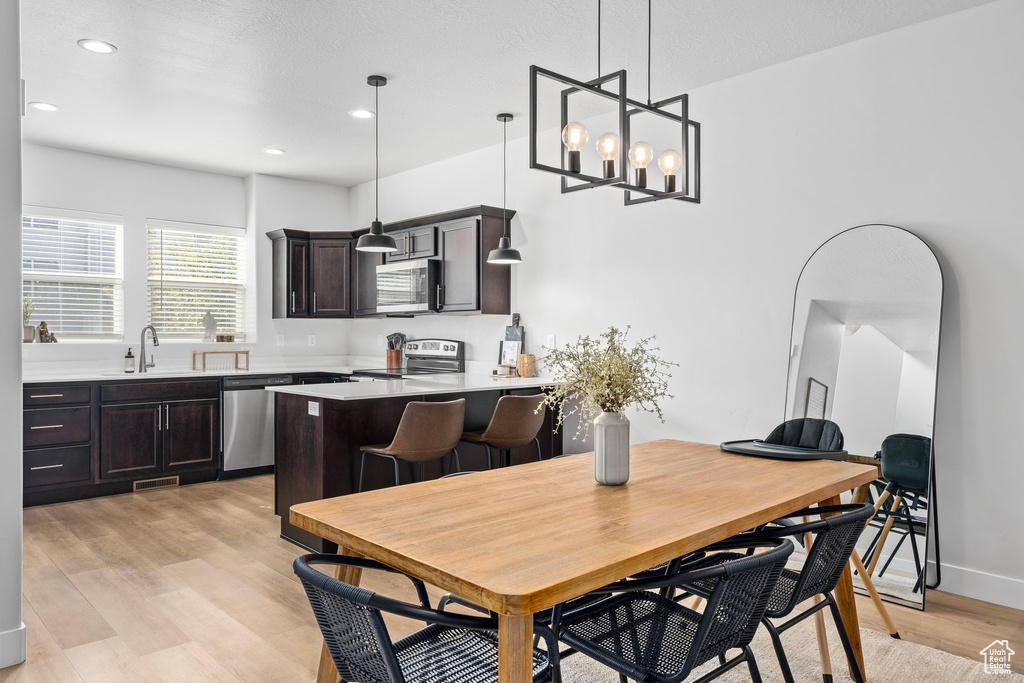 Dining area featuring a chandelier, sink, and light hardwood / wood-style floors