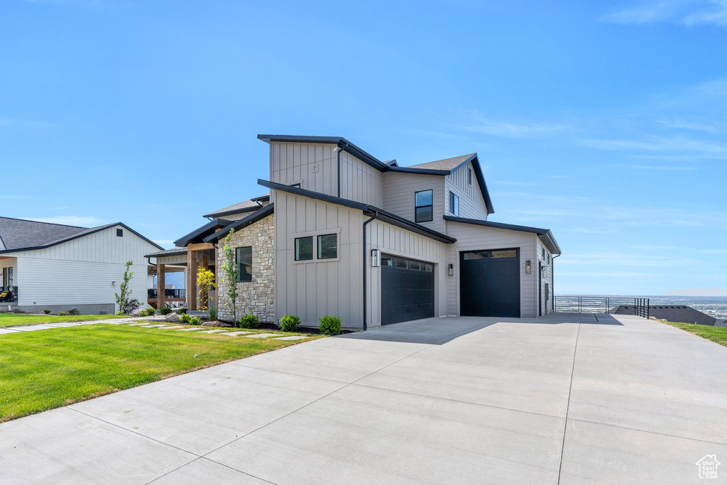 View of side of home with board and batten siding and concrete driveway