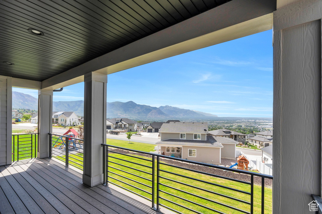 Deck featuring a residential view, a mountain view, and a lawn