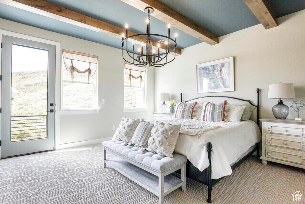 Carpeted bedroom featuring access to exterior, beamed ceiling, and a notable chandelier