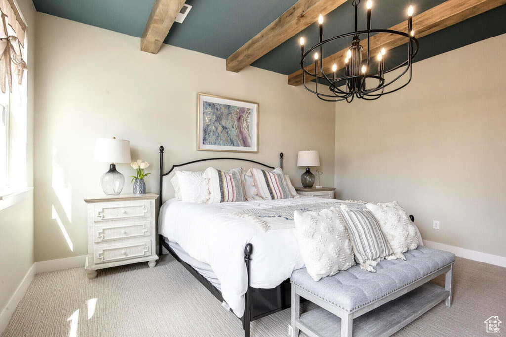 Bedroom with an inviting chandelier, beam ceiling, and carpet