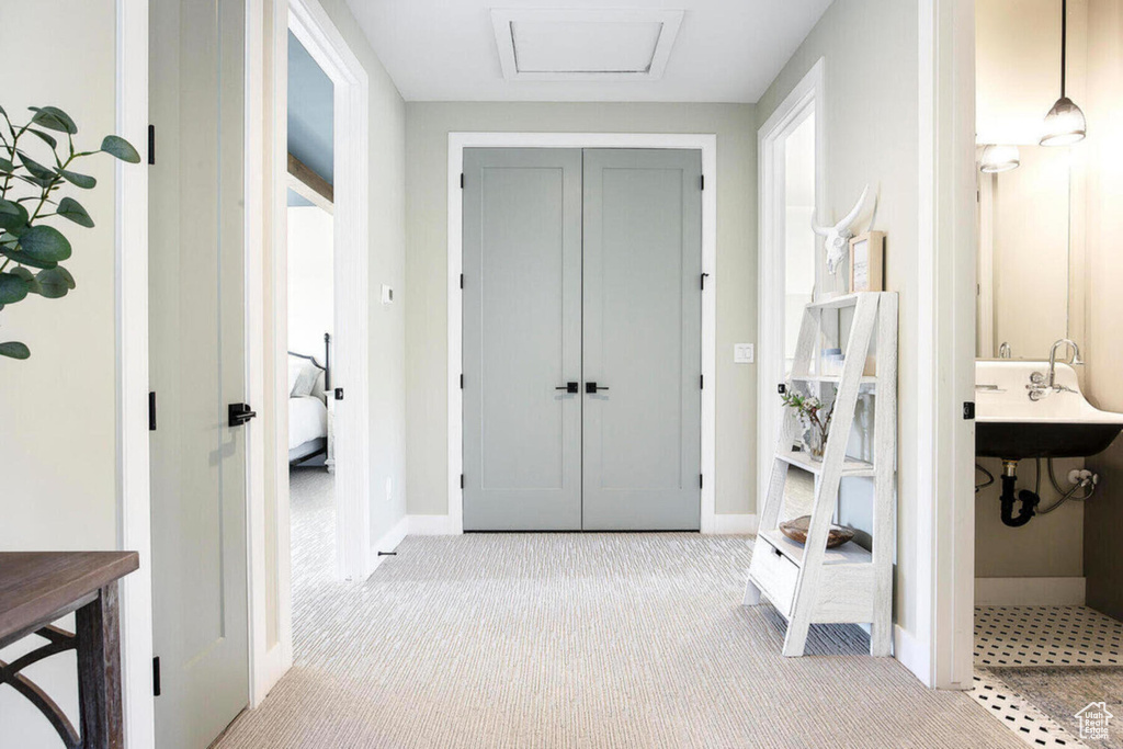 Hall with light colored carpet and sink