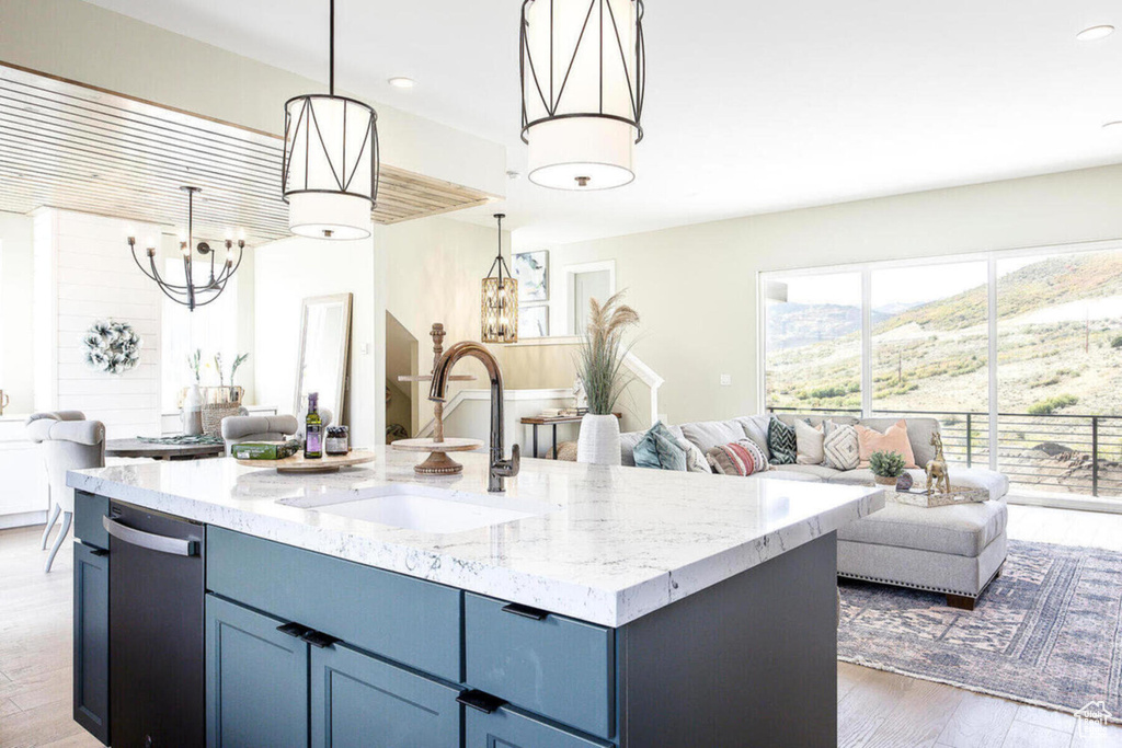 Kitchen featuring a kitchen island with sink, dark hardwood / wood-style floors, sink, pendant lighting, and a mountain view