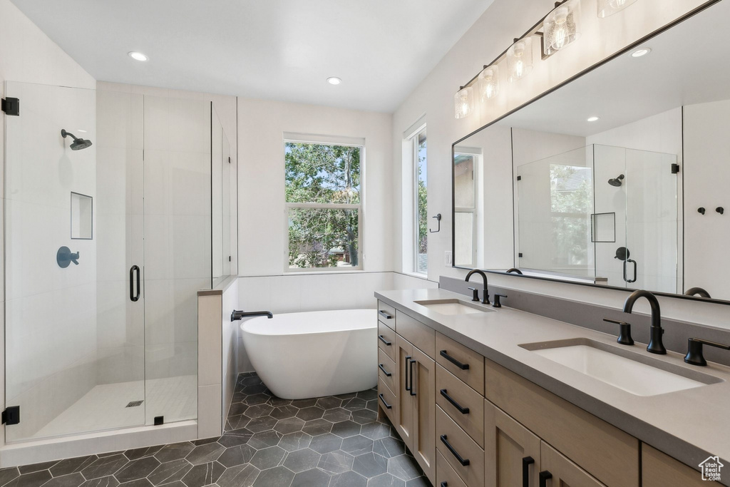 Bathroom featuring tile patterned floors, vanity, and independent shower and bath