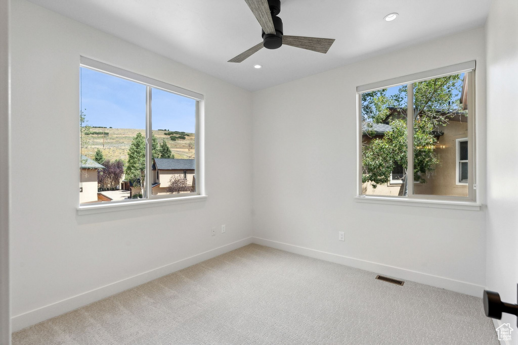 Carpeted spare room with ceiling fan