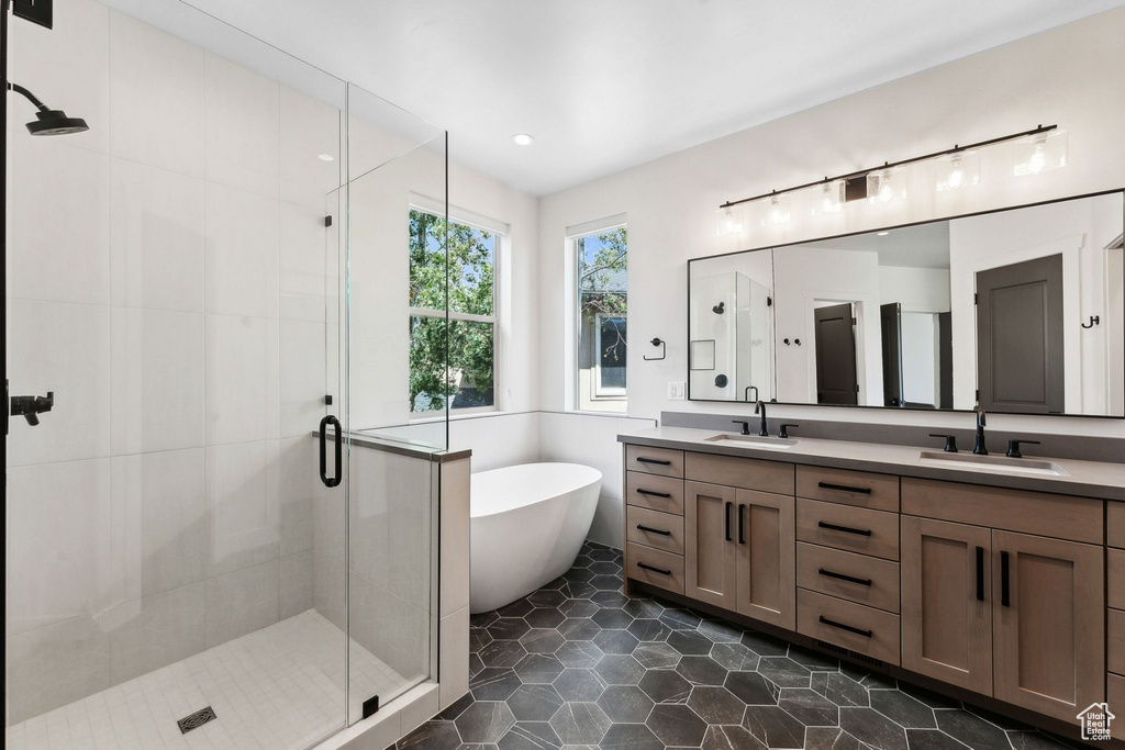 Bathroom featuring tile patterned flooring, separate shower and tub, and vanity