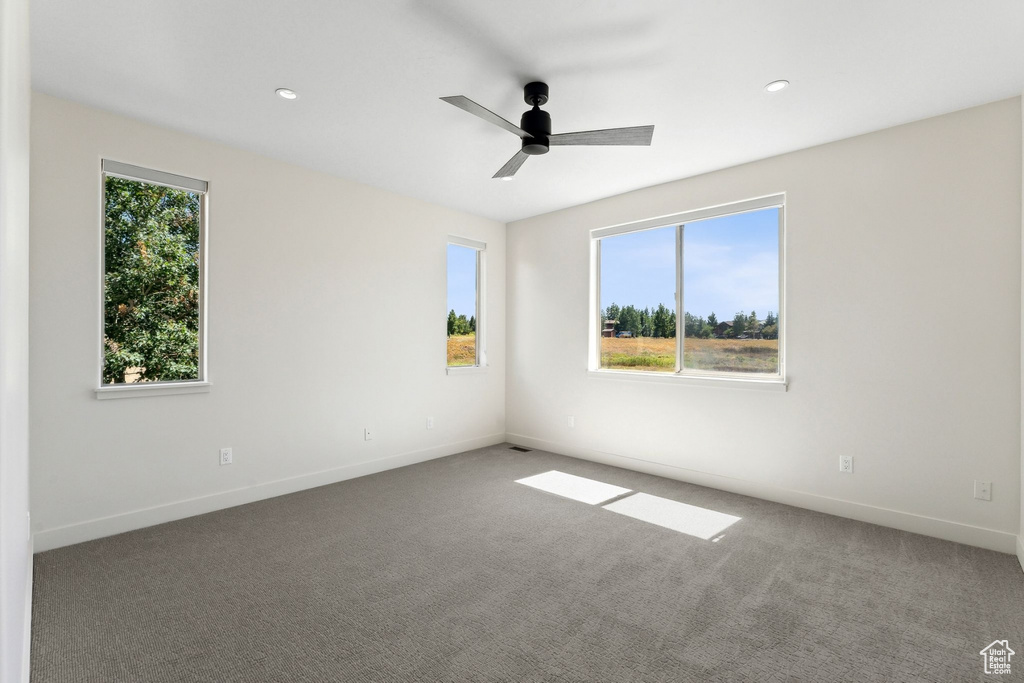 Empty room featuring ceiling fan and carpet flooring