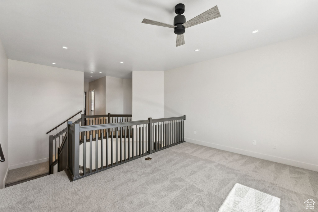 Spare room featuring light carpet and ceiling fan