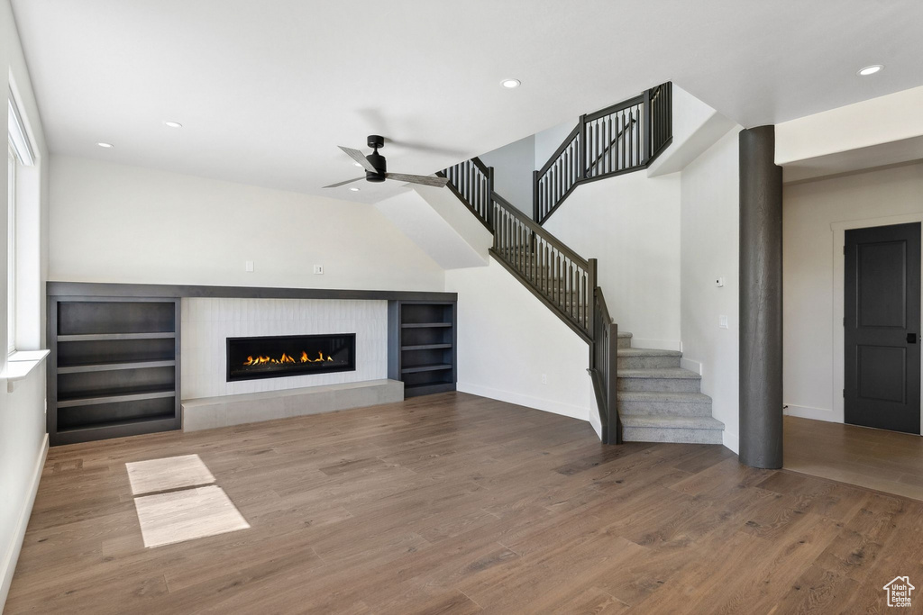 Unfurnished living room with a fireplace, hardwood / wood-style floors, and ceiling fan