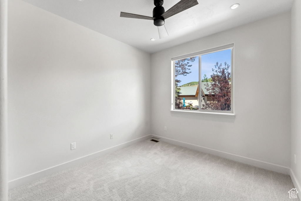 Carpeted spare room with ceiling fan