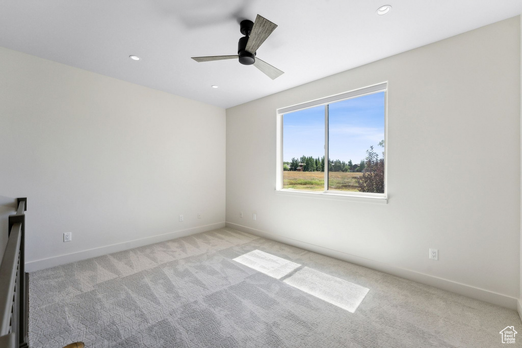 Carpeted spare room featuring ceiling fan