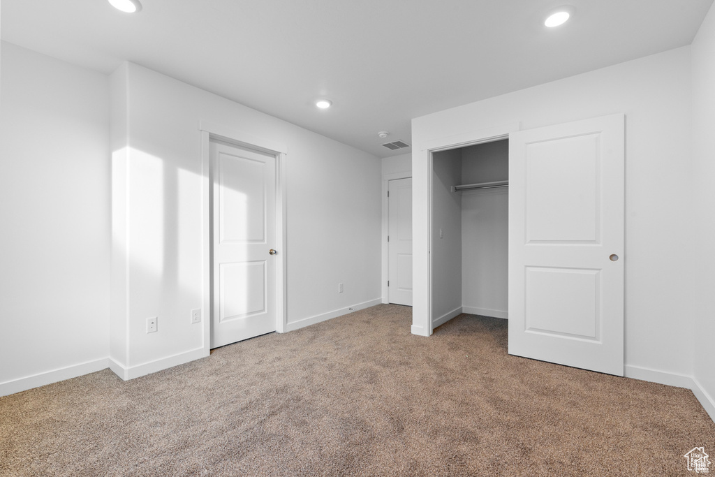 Unfurnished bedroom featuring carpet floors and a closet