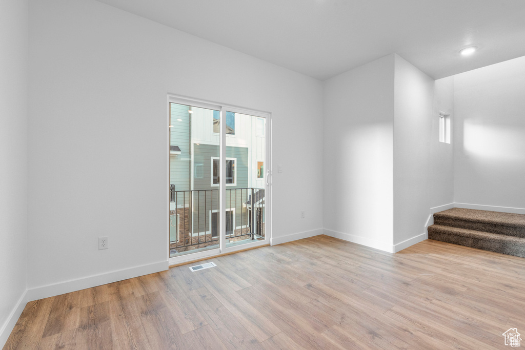 Empty room with light hardwood / wood-style flooring