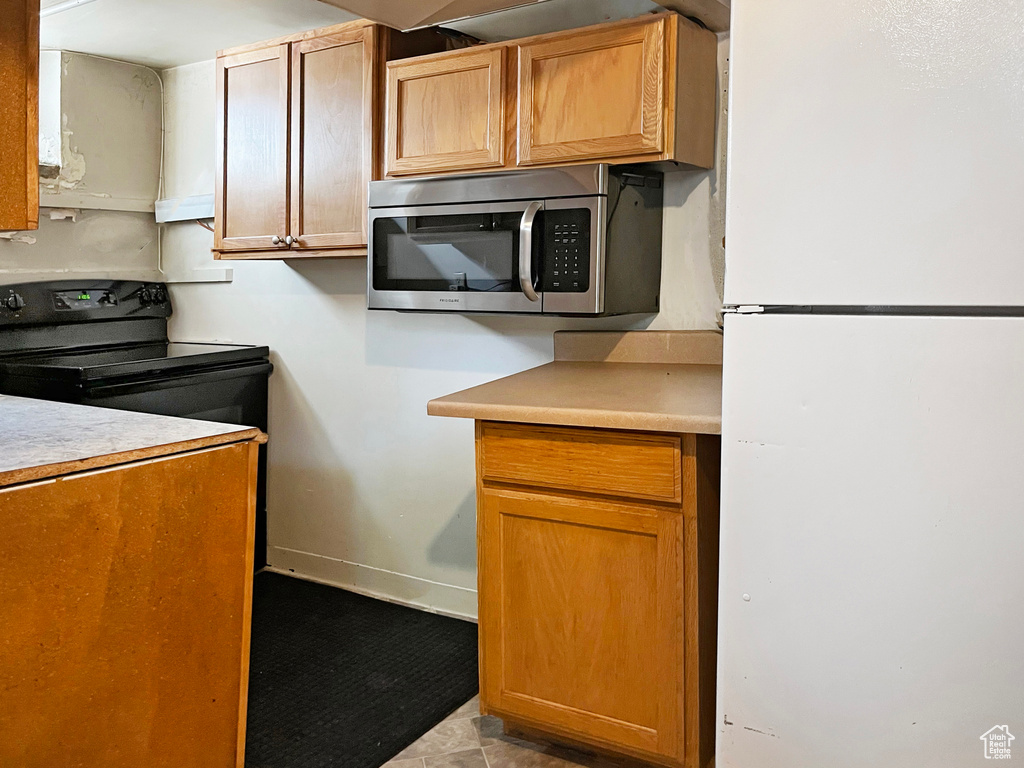 Kitchen with ventilation hood and white fridge