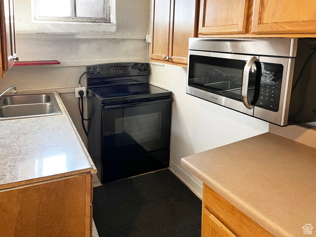 Kitchen with black electric range oven and sink