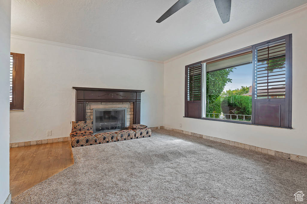 Unfurnished living room featuring ornamental molding, a wealth of natural light, and wood-type flooring