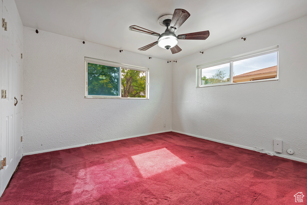 Unfurnished room featuring ceiling fan and carpet floors