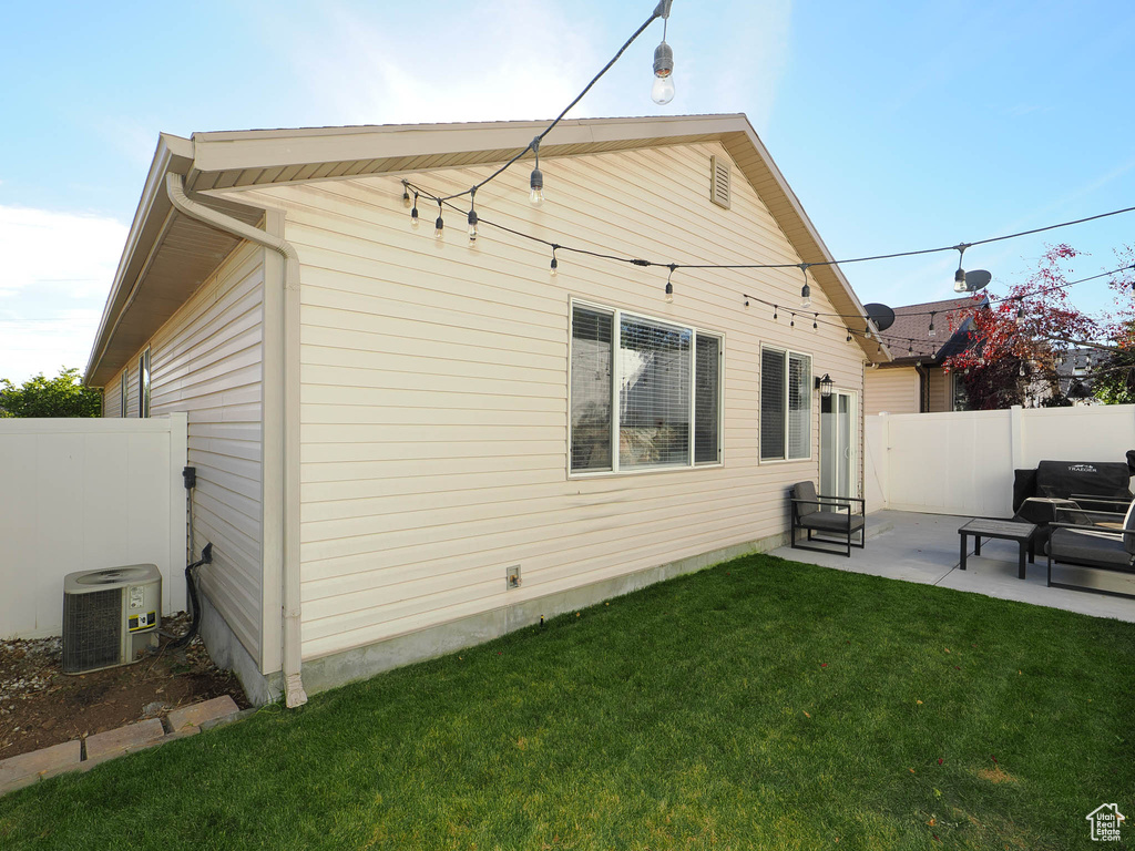 Rear view of property with a yard, central AC, and a patio