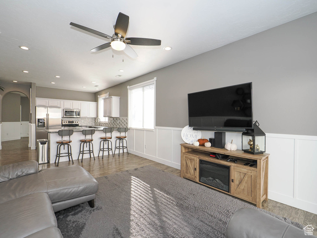 Living room featuring ceiling fan, dark wood-type flooring, and sink