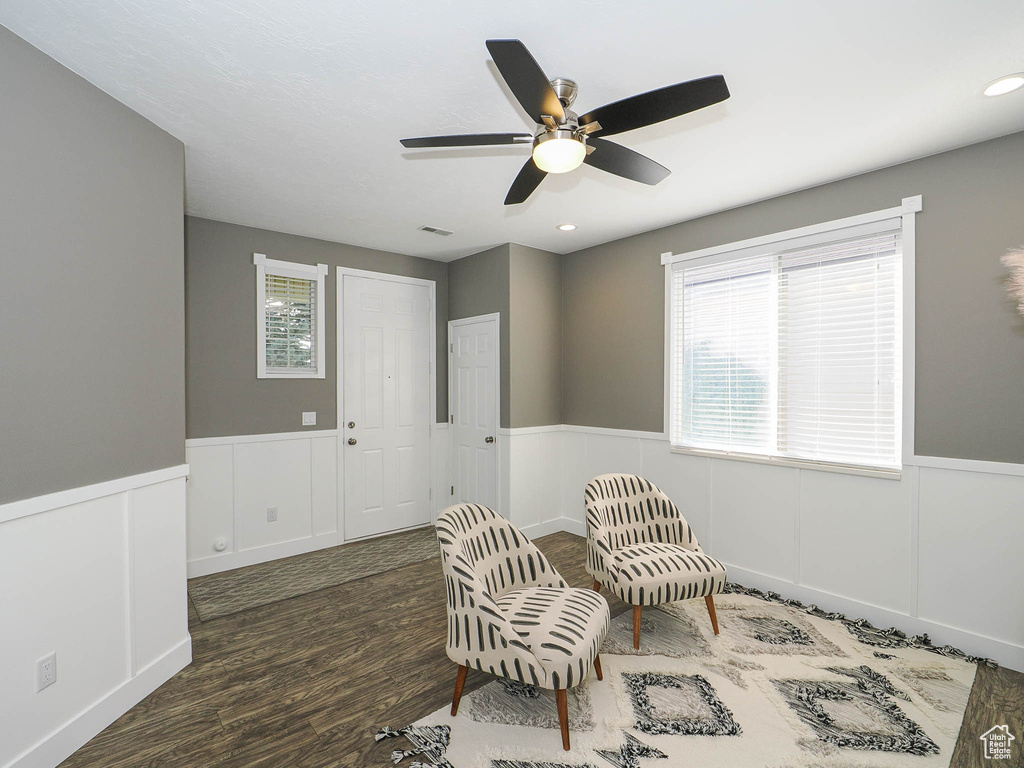 Living area with ceiling fan and dark hardwood / wood-style floors