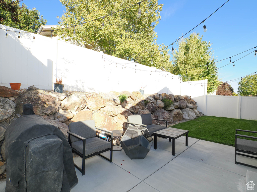 View of patio with a grill