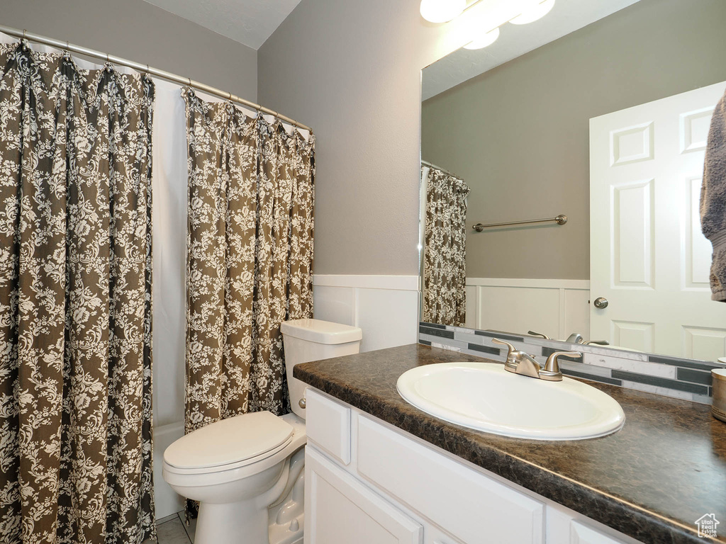 Full bathroom featuring shower / bath combo, vanity, and toilet