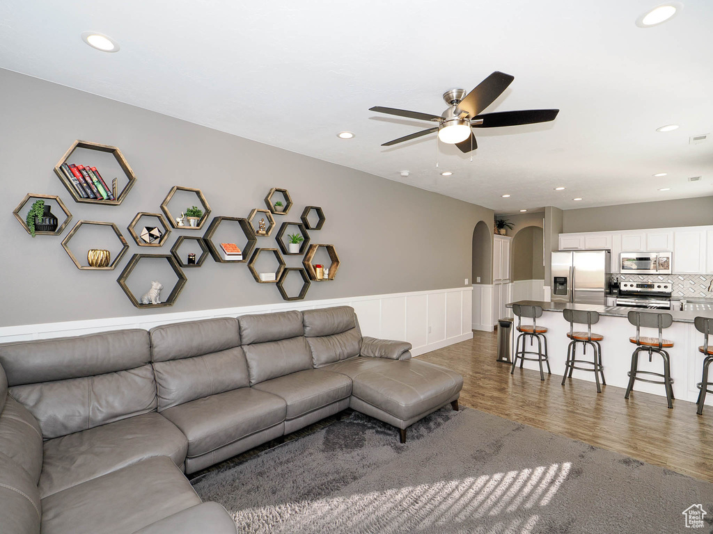 Living room featuring ceiling fan and dark hardwood / wood-style flooring