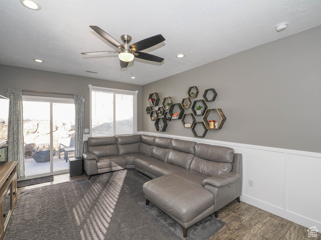 Living room featuring ceiling fan and dark hardwood / wood-style flooring