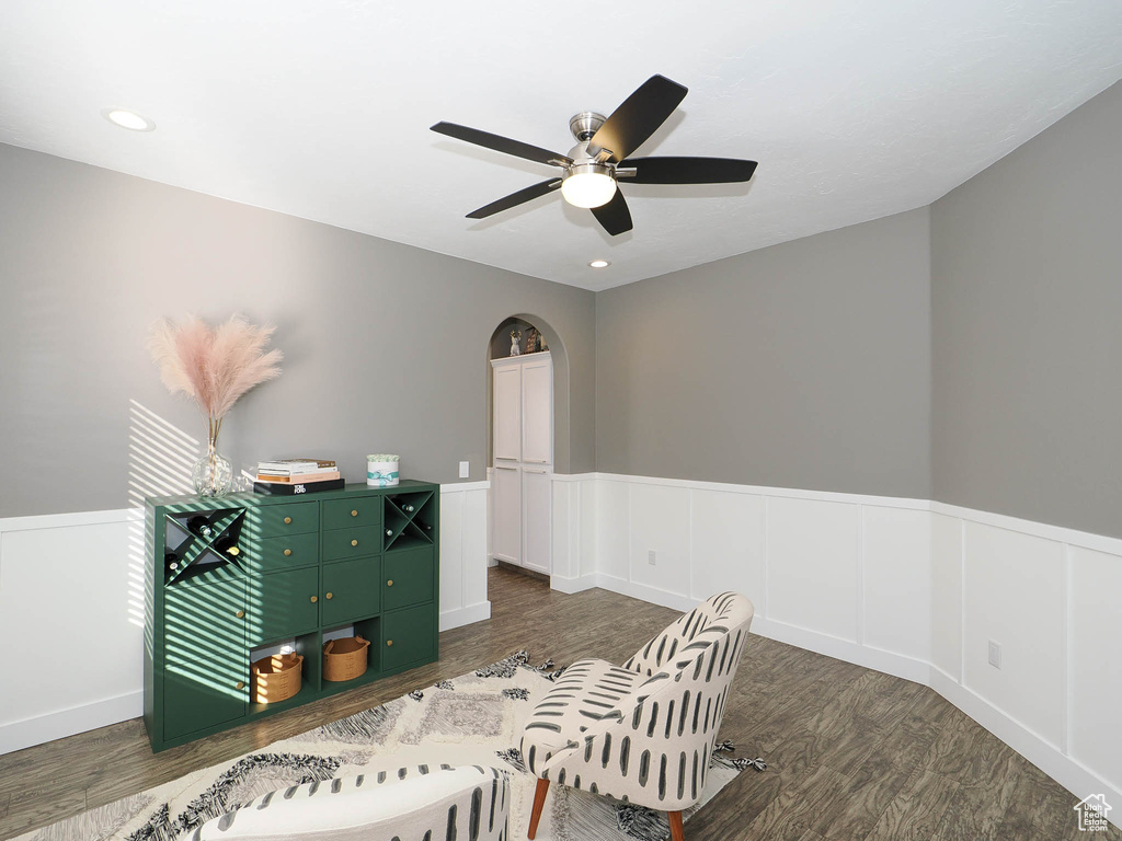 Sitting room featuring dark wood-type flooring and ceiling fan