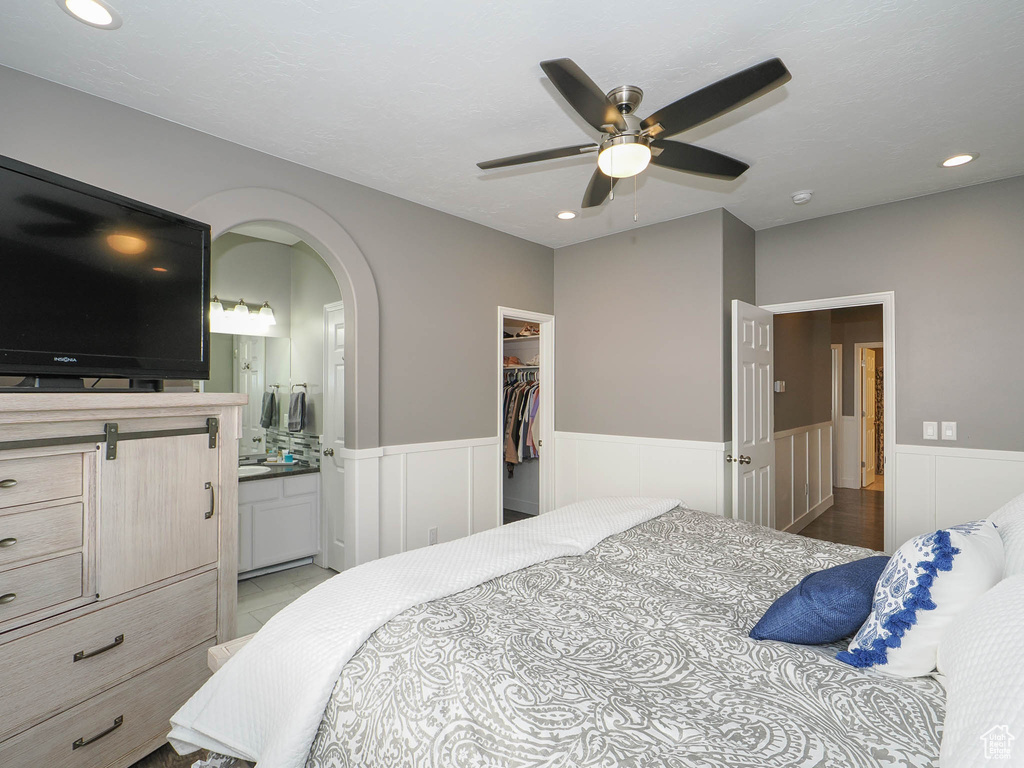 Bedroom featuring ceiling fan, a closet, ensuite bathroom, and a walk in closet