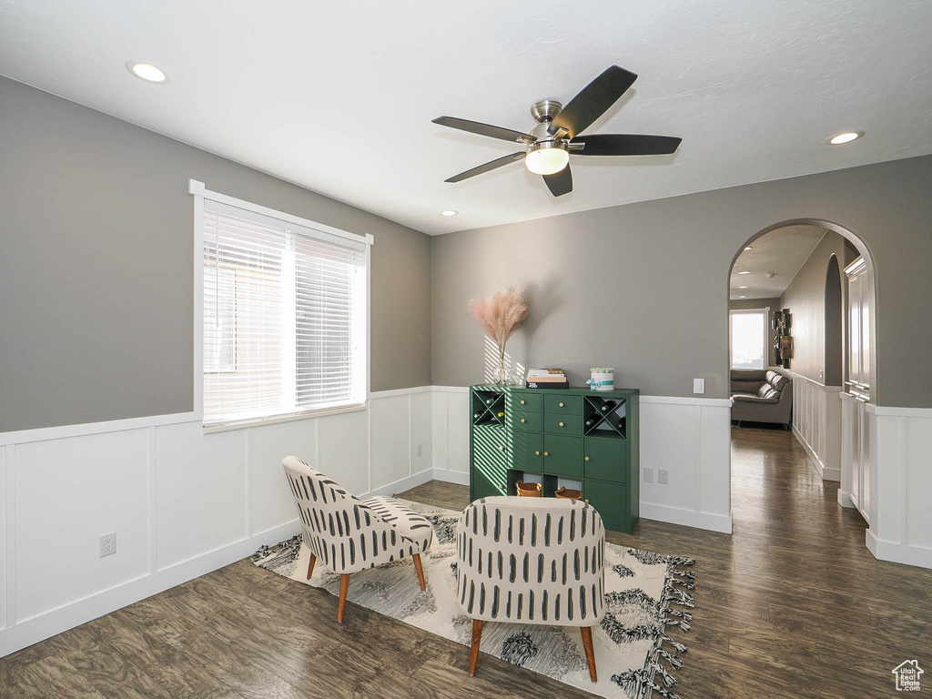 Sitting room with ceiling fan and dark wood-type flooring