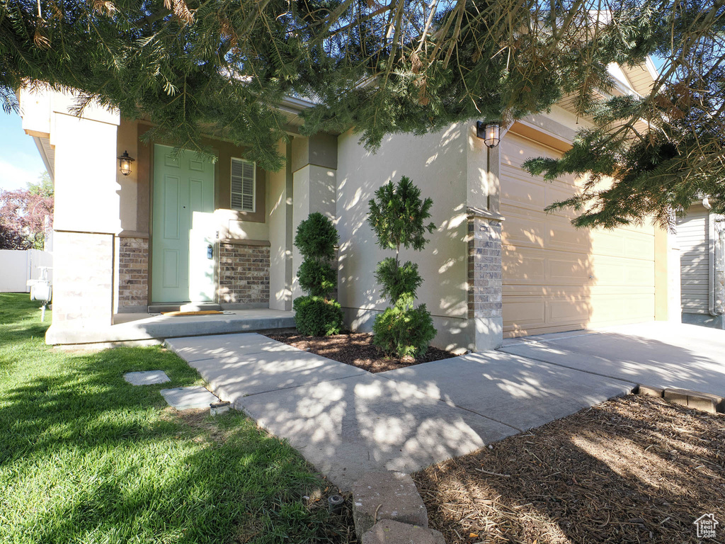 View of front facade featuring a garage and a front lawn