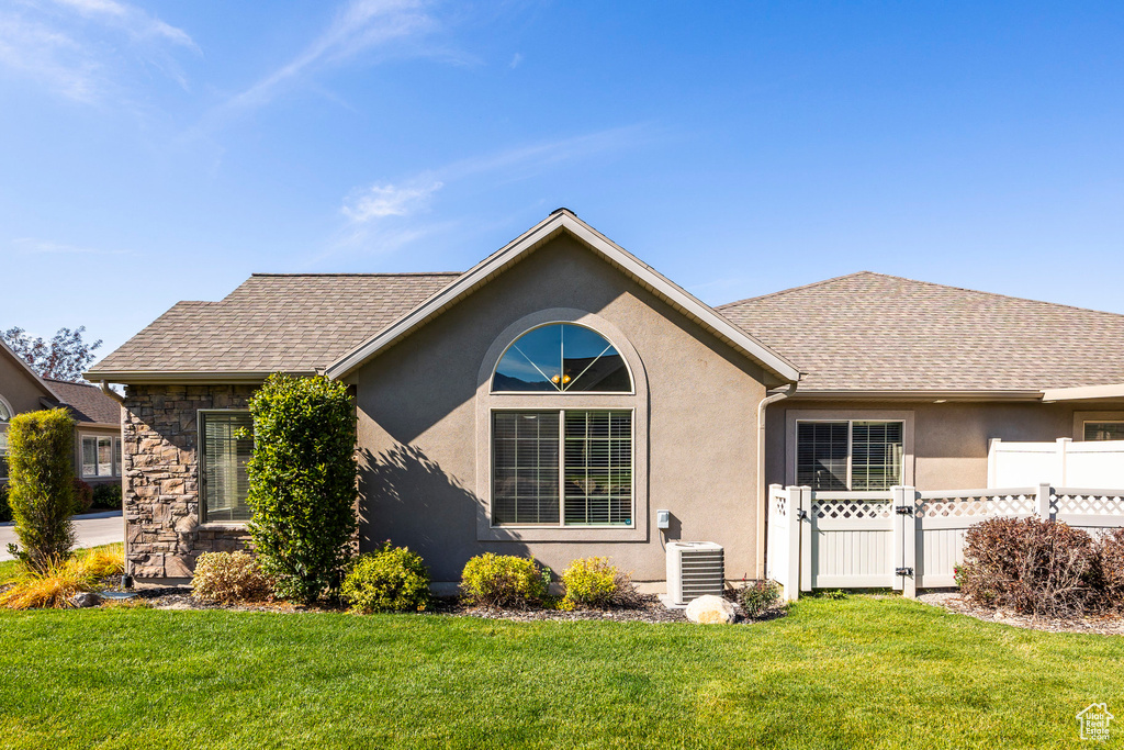 Single story home with a front yard and cooling unit