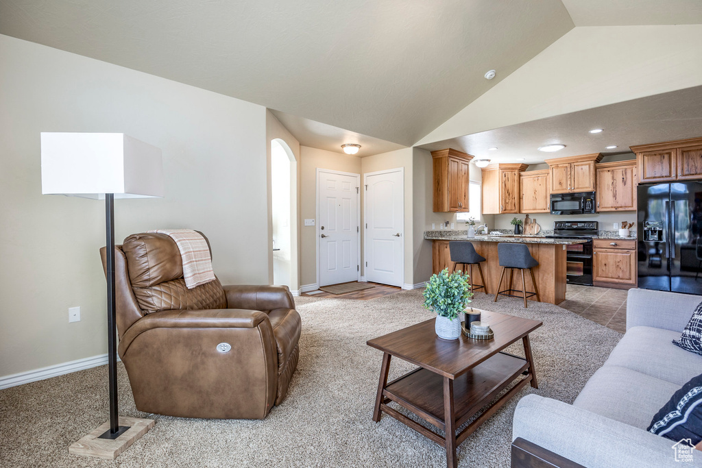 Living room featuring lofted ceiling and light colored carpet