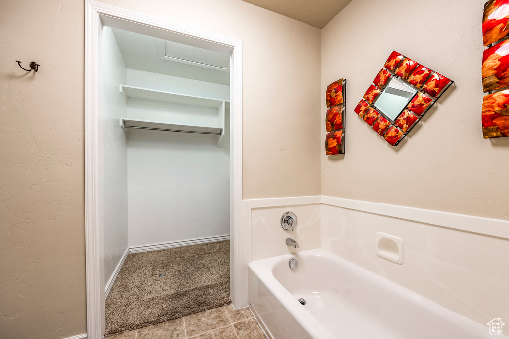 Bathroom featuring a tub to relax in and tile patterned floors